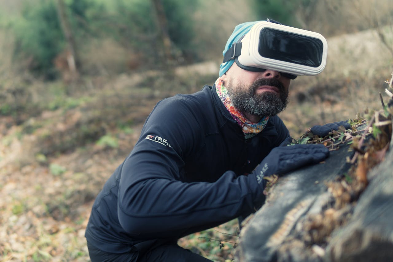 services-02 A bearded man in a park using a virtual reality headset to explore nature.